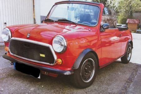 Dieses Foto zeigt den Mini MK V, einen Oldtimer aus dem Jahr 1990, der aktuell bei My Next Classic zum Verkauf angeboten wird. Der Umbau zum Cabriolet erfolgte durch die Firma Mengers Special Cars Oldenburg. Die Silhouette des Minis wurde beim Umbau beibehalten. Der Mini ist erst 21.800 km gelaufen und erreicht bei der Fahrzeugbewertung eine Zustandsnote von 2-. Eine gültige HU und ein Saisonkennzeichen sind vorhanden.