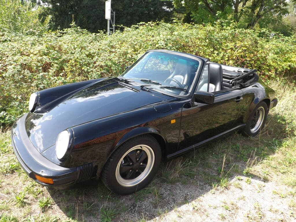 Dieses Foto zeigt das Porsche 911 Carrera Cabriolet, einen Oldtimer aus dem Jahr 1985, der aktuell bei My Next Classic zum Verkauf angeboten wird. Ein absoluter Traumwagen mit 231 PS in der begehrten Farbkombination schwarz/schwarz. Das Fahrzeug aus 2. Hand befindet sich im Top-Zustand.