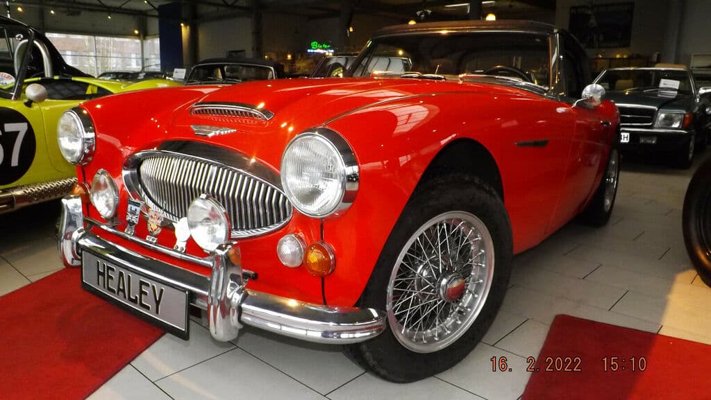 Dieses Foto zeigt den Austin Healey 3000 MK III BJ8, ein Oldtimer-Sportcabriolet aus dem Jahr 1966, das aktuell bei My Next Classic zum Verkauf angeboten wird. 2,9 Liter Hubraum und 150 PS aus einem Reihensechszylinder treffen auf lediglich 1.100 kg Leergewicht. Das Fahrzeug wurde vollständig restauriert, ist perfekt lackiert und die Innenausstattung ist wie neu. Ein detailliertes Wertgutachten und eine umfassende Dokumentation liegen vor.
