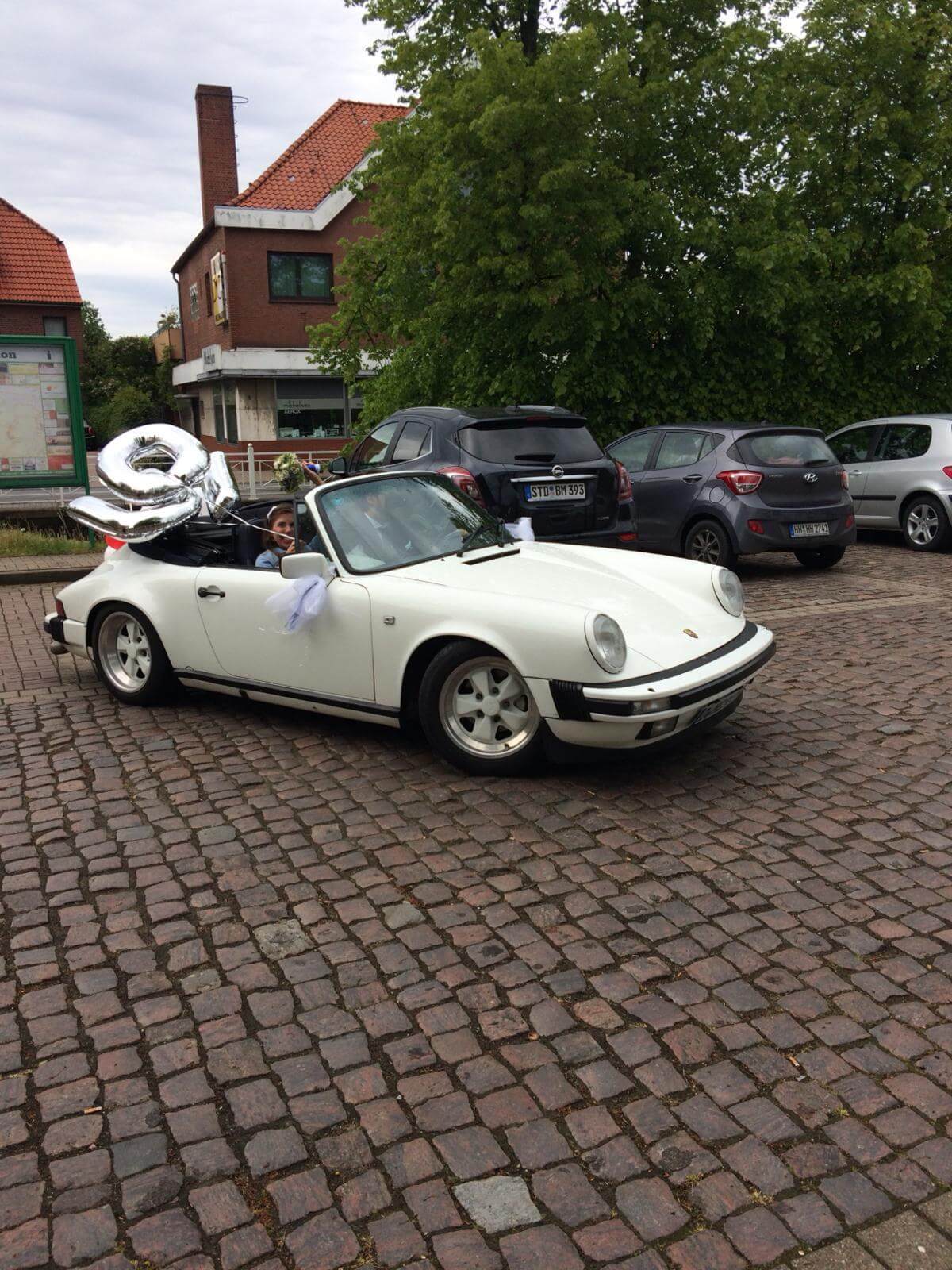 Dieses Foto zeigt den Porsche 911 Carrera, einen Oldtimer aus dem Jahr 1983. Das Fahrzeug besitzt ein H-Kennzeichen, HU/AU werden frisch erneuert, die Fuchsfelgen sind in Wagenfarbe weiß und das Stoffdach ist dunkelblau. Das Auto ist in einem guten Zustand. Biete jetzt mit und ersteigere diesen