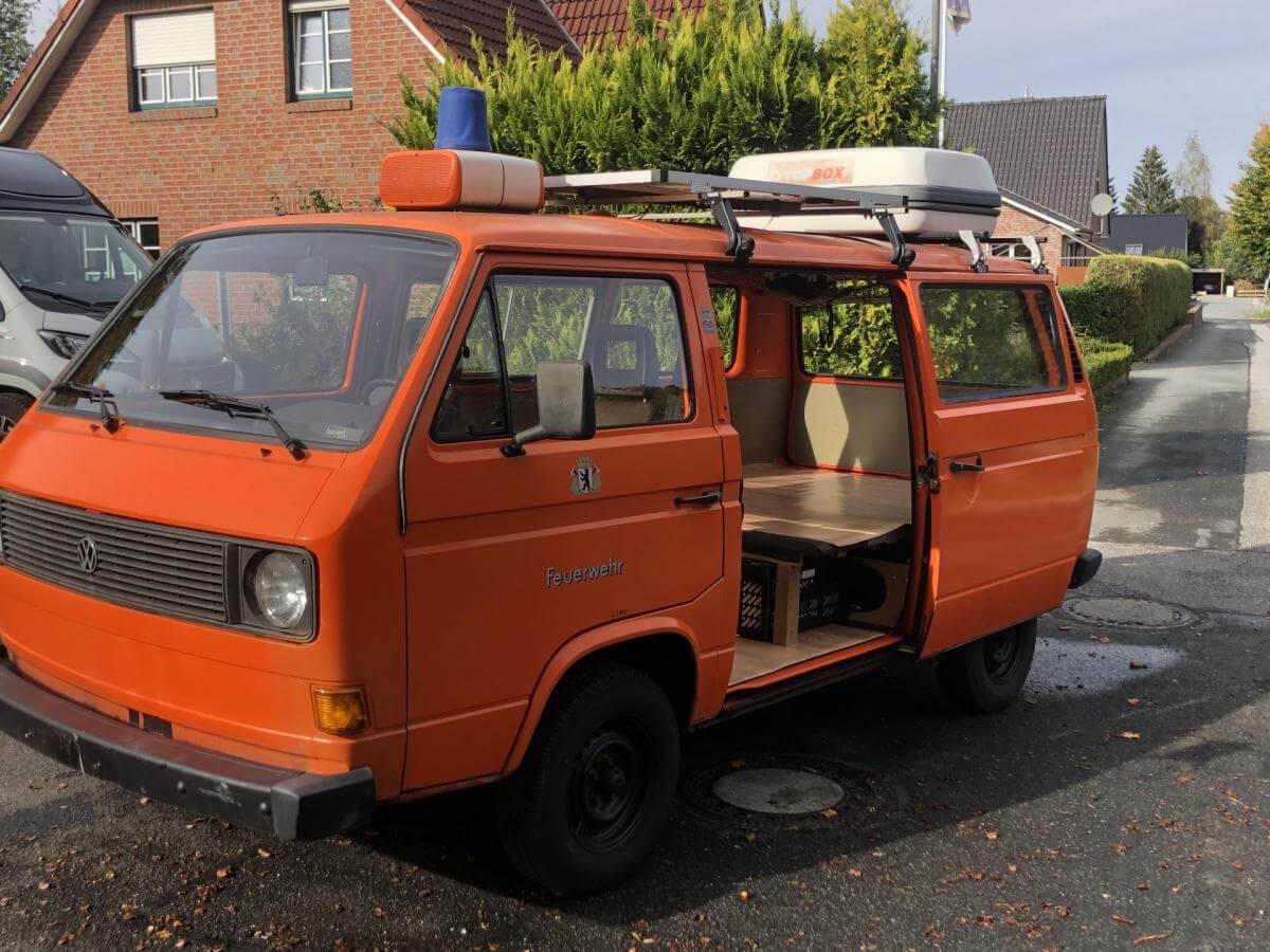 Dieses Foto zeigt den Volkswagen Bus, einen Oldtimer aus dem Jahr 1982. Es handelt sich um einen Ex-Feuerwehrmannschaftswagen (Luftboxer) in der Farbe Orange. Das Fahrzeug hat TÜV, ist voll fahrbereit und bietet einige Extras. Außerdem hat es Solar auf dem Dach, zwei Schiebetüren, Schiebefenster auf der Beifahrerseite, originale Sitzbänke und zahlreiche feuerwehrspezifische Teile. Biete jetzt mit!